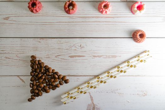 flatlay concept abstract showing coffee beans, straws, candies candles on a white wooden background perfect for a cafe menu or restaurant with copyspace. Shows the elegance of a bakery making winter drinks for christmas, thanksgiving and just spring