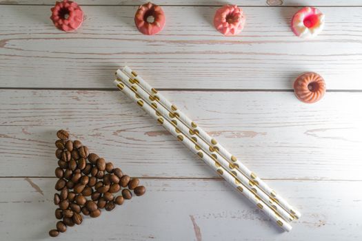 flatlay concept abstract showing coffee beans, straws, candies candles on a white wooden background perfect for a cafe menu or restaurant with copyspace. Shows the elegance of a bakery making winter drinks for christmas, thanksgiving and just spring