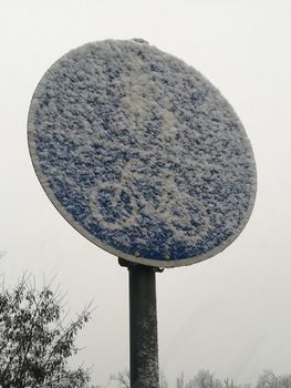 Blue pedestrian and cyclists traffic sign under snow