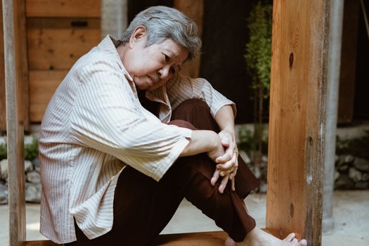 stressed depressed fatigued sad upset asian old asian elderly senior elder woman sitting at home