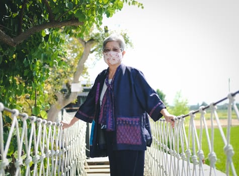 asian elderly woman elder wearing facial mask resting relaxing outdoors. senior leisure lifestyle