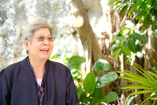 elder woman resting in garden. asian elderly female relaxing outdoors. senior leisure lifestyle