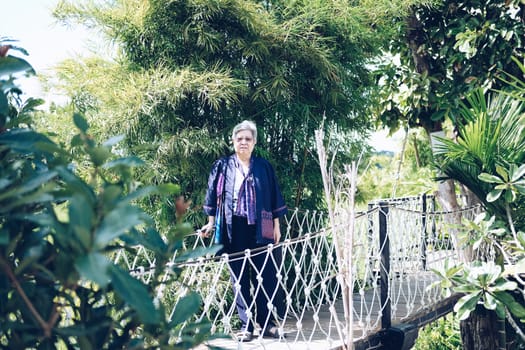elder woman resting in garden. asian elderly female relaxing outdoors. senior leisure lifestyle