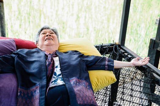 asian elderly woman elder  lying resting relaxing outdoors. senior leisure lifestyle