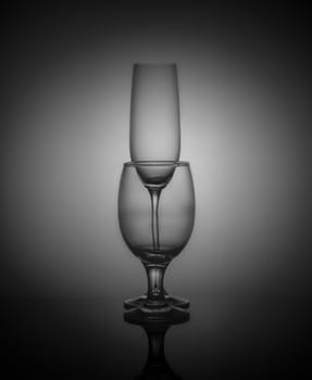 empty drink glasses placed one after another on dark background with back light.