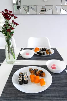 Fresh sushi and rolls in a white plate. Sushi lunch.