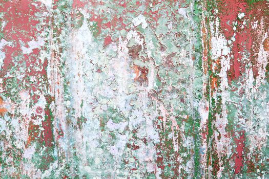 Detailed and colorful close up at cracked and peeling paint on concrete wall textures in high resolution.