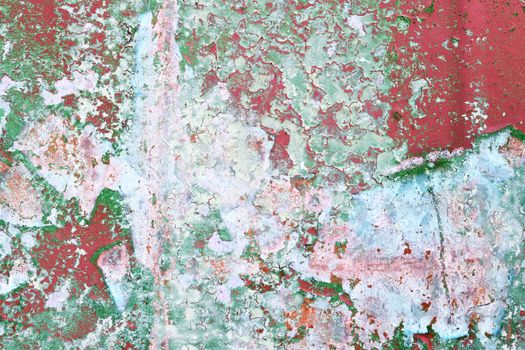 Detailed and colorful close up at cracked and peeling paint on concrete wall textures in high resolution.