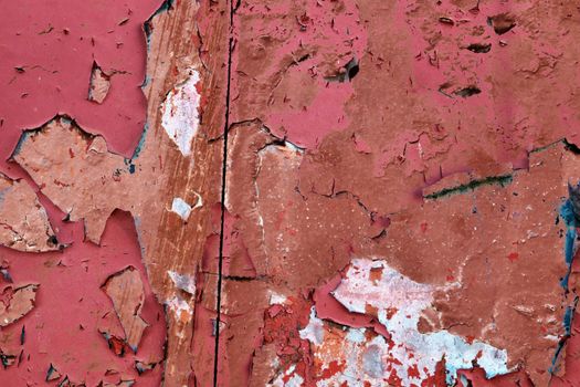 Detailed and colorful close up at cracked and peeling paint on concrete wall textures in high resolution.