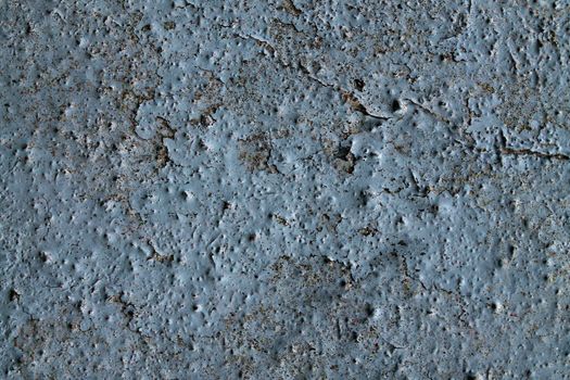 Detailed and colorful close up at cracked and peeling paint on concrete wall textures in high resolution.