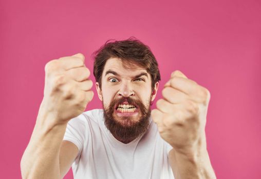 Man on a pink background surprise irritability emotions and stress. High quality photo