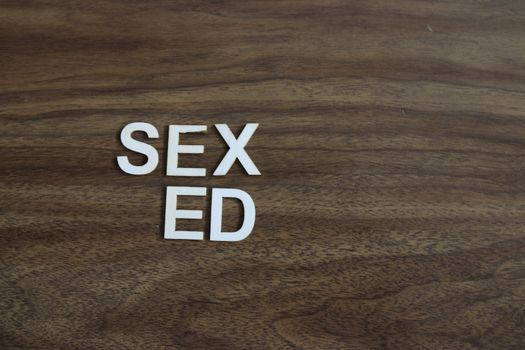Wooden blocks with phrase `SEX ED` on light blue background. High quality photo