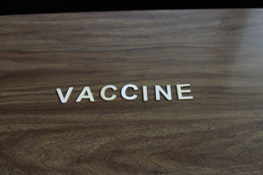 the word vaccine on a wood background. room for copyspace. High quality photo