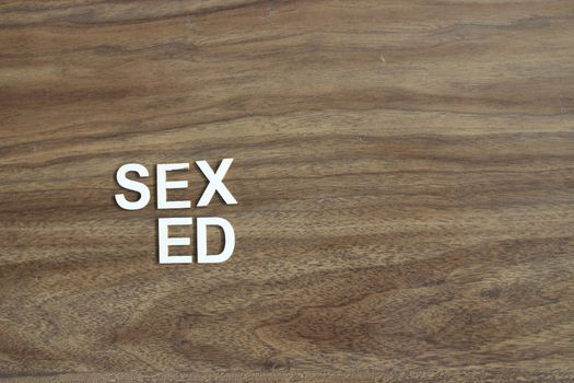 Wooden blocks with phrase `SEX ED` on light blue background. High quality photo