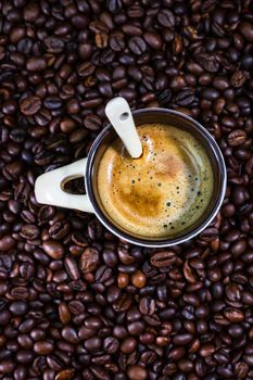 Coffee cup with roasted coffee beans on red background, coffee concept, close up coffee photo