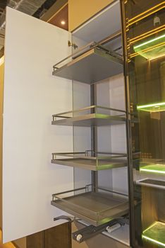 Interior design decor of kitchen in luxury apartment showing closeup detail of sliding cupboard unit with shelves