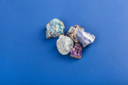 set of close up Natural minerals, precious stones on classic blue background. Use for jewelry. Space for text.