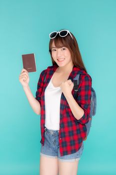 Beautiful portrait young asian woman wear sunglasses on head smile excited and enjoy summer holiday isolated blue background, asia girl hipster cheerful holding passport for travel trip concept.