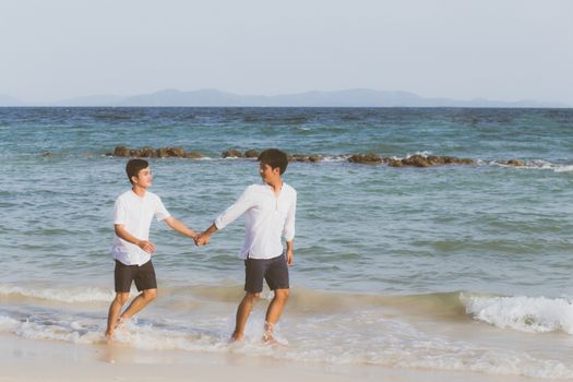 Homosexual portrait young asian couple running with cheerful together on beach in summer, asia gay going tourism for leisure and relax with happiness in vacation at sea, LGBT legal concept.