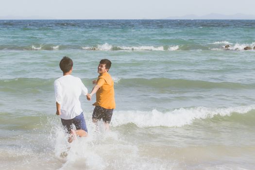 Homosexual portrait young asian couple running with cheerful together on beach in summer, asia gay going tourism for leisure and relax with happiness in vacation at sea, LGBT legal concept.