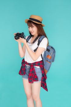 Beautiful young asian woman cheerful and enjoy travel trip summer isolated on blue background, asia girl having activity hobby take a photo holding camera, tourist journey in vacation and holiday.