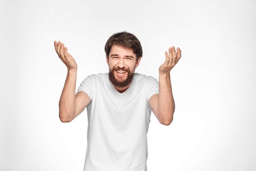 cheerful emotional bearded man gesturing with his hands close-up light background. High quality photo