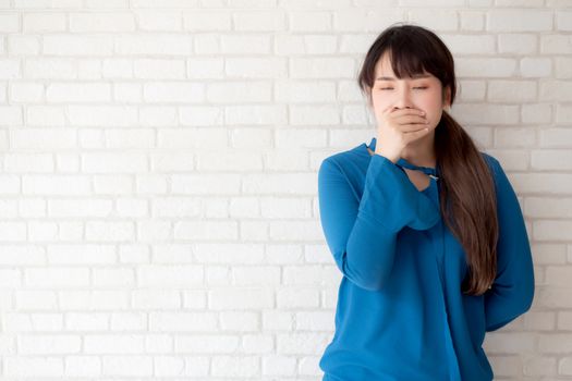 Beautiful portrait young asian woman yawning and sleepy on grey cement texture grunge wall brick background, beauty asia girl expression lazy and bored, female leisure and relax, lifestyle concept.