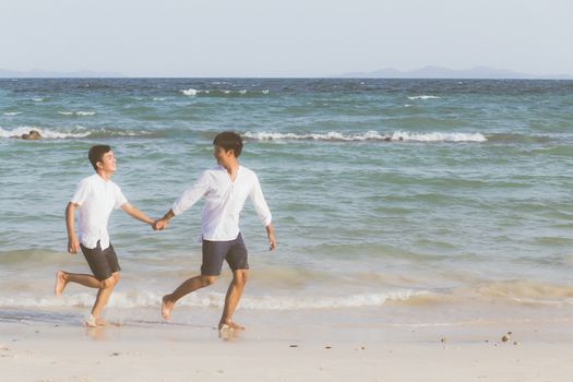 Homosexual portrait young asian couple running with cheerful together on beach in summer, asia gay going tourism for leisure and relax with happiness in vacation at sea, LGBT legal concept.