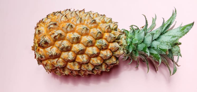 tasty and healthy orange colored pineapple closeup on pink colored background