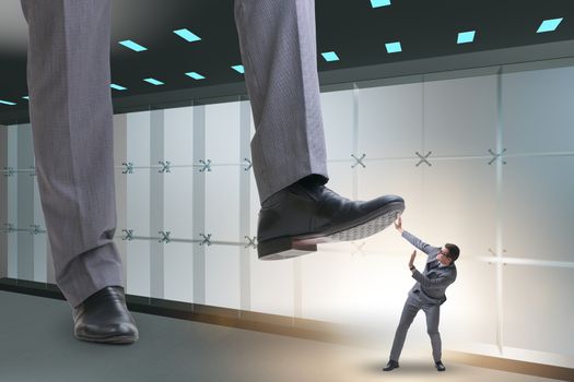 Bad angry boss stamping on employee in business concept