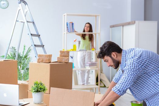 Young family unpacking at new house with boxes