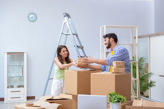 Young family unpacking at new house with boxes