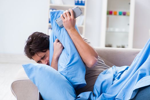 Man watching tv from bed holding remote control unit