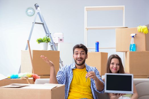 Young family unpacking at new house with boxes
