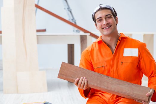 Contractor working on laminate wooden floor 