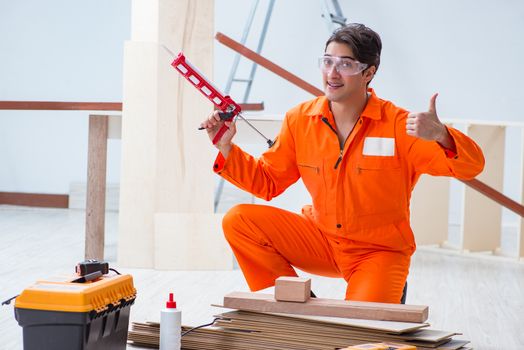 Contractor working on laminate wooden floor 