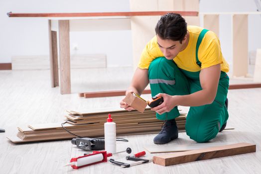 Contractor working on laminate wooden floor 
