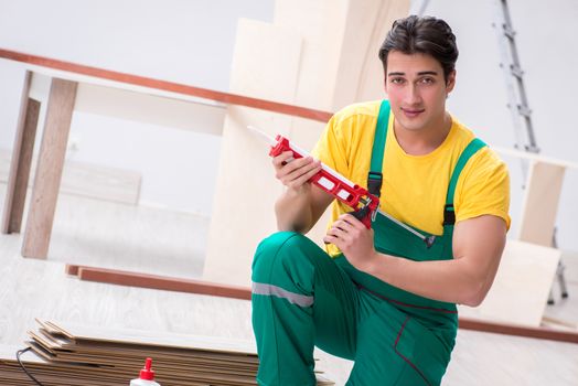 Contractor working on laminate wooden floor 