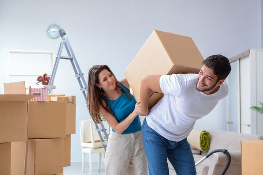 Young family unpacking at new house with boxes