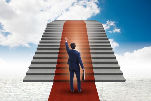 Young businessman climbing stairs and red carpet into sky