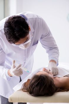 Police coroner examining dead body corpse in morgue