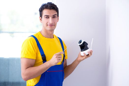 Contractor installing surveillance CCTV cameras in office