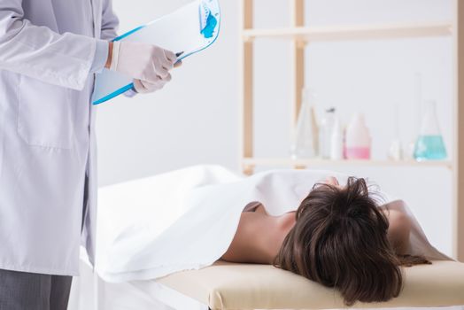 Police coroner examining dead body corpse in morgue