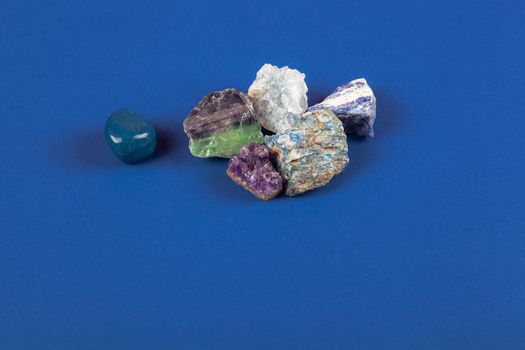 set of close up Natural minerals, precious stones on classic blue background. Use for jewelry. Space for text.