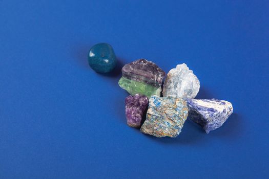 set of close up Natural minerals, precious stones on classic blue background. Use for jewelry. Space for text.