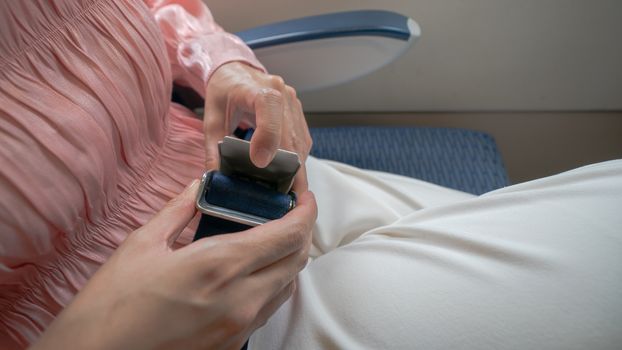 Close up of women fasten seat belt on the airplane.