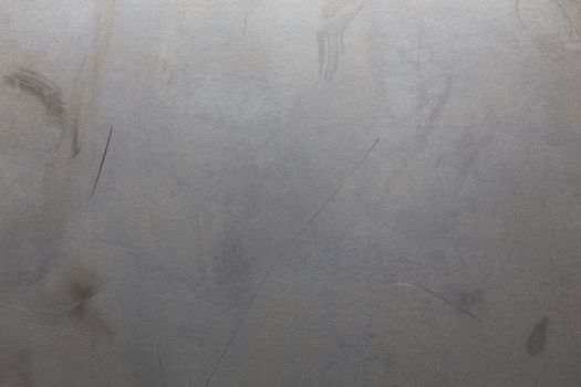 Uncoated flat cold rolled metal sheet surface with minor scratches. Close-up in directly above composition.