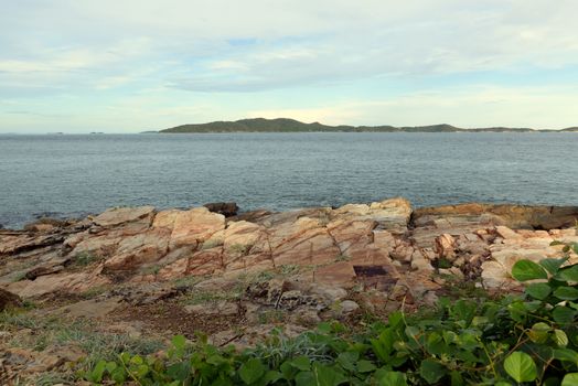 Coastal sea pictures With creepers and cracked rocks in the foreground And there are islands against the sky in the background. Eastern tourist attractions of Thailand.