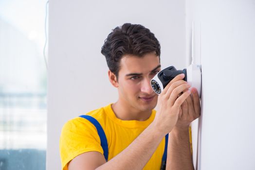 Contractor installing surveillance CCTV cameras in office