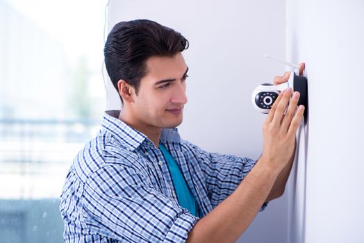 Man installing surveillance CCTV cameras at home